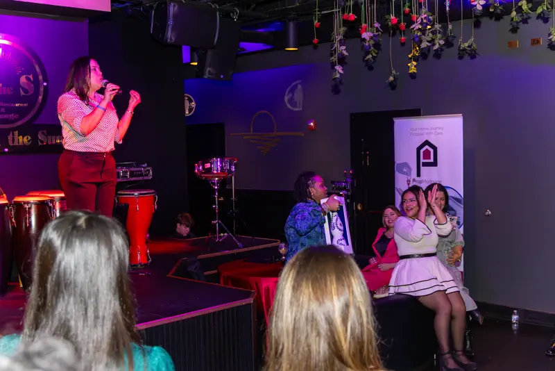 A singer on stage under the house lights.