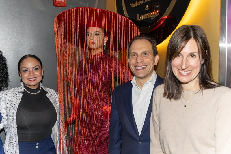 Guests photographed at the step-and-repeat backdrop.